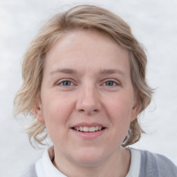 Joyful white young-adult female with medium  brown hair and blue eyes