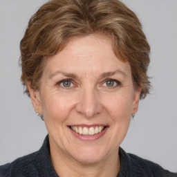 Joyful white adult female with medium  brown hair and grey eyes