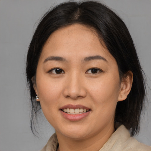 Joyful asian young-adult female with medium  brown hair and brown eyes