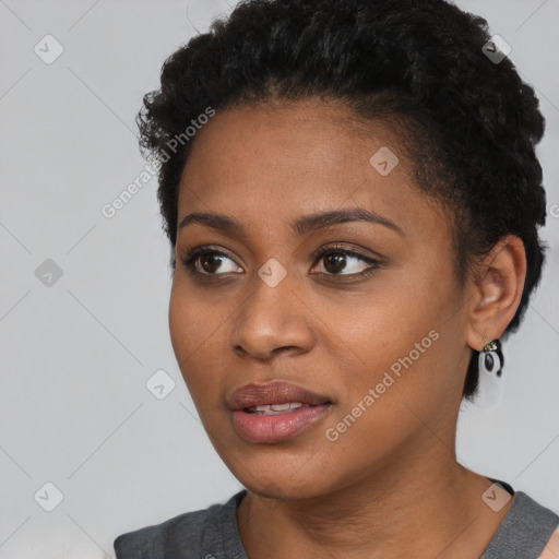 Joyful black young-adult female with short  black hair and brown eyes