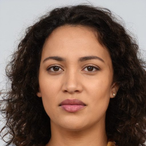 Joyful latino young-adult female with long  brown hair and brown eyes