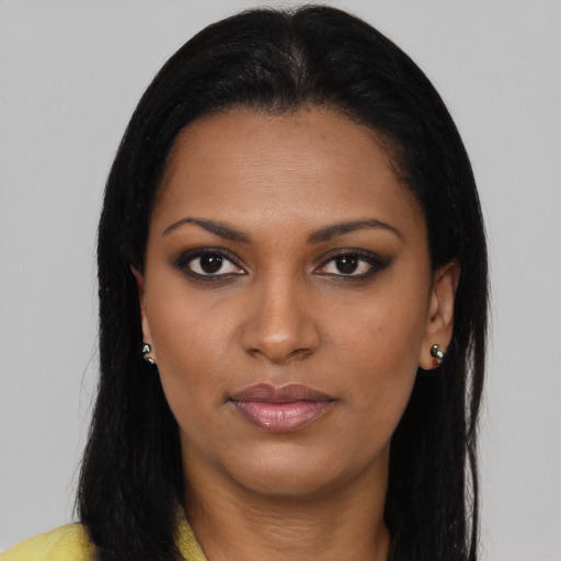 Joyful black young-adult female with long  brown hair and brown eyes