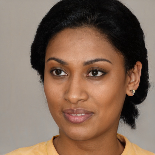 Joyful black young-adult female with short  black hair and brown eyes