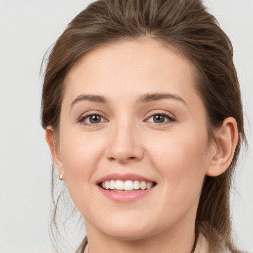 Joyful white young-adult female with medium  brown hair and grey eyes