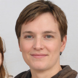 Joyful white young-adult female with medium  brown hair and grey eyes