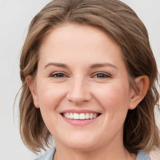 Joyful white young-adult female with medium  brown hair and blue eyes