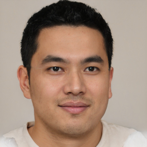 Joyful latino young-adult male with short  brown hair and brown eyes