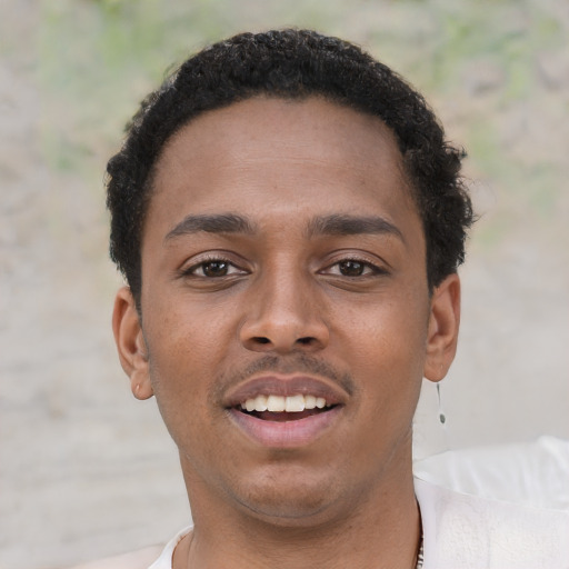 Joyful black young-adult male with short  brown hair and brown eyes