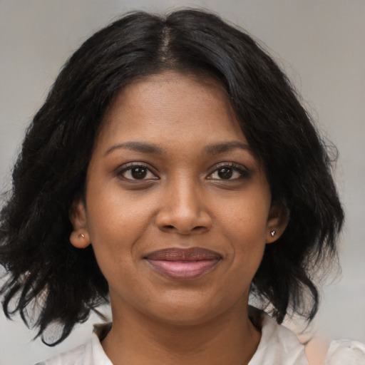 Joyful black young-adult female with medium  brown hair and brown eyes