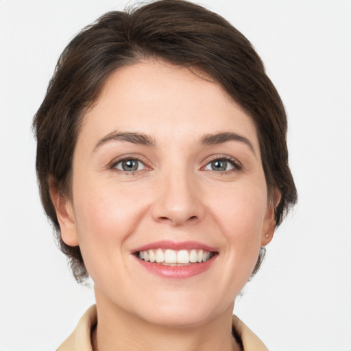 Joyful white young-adult female with medium  brown hair and grey eyes