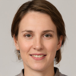 Joyful white young-adult female with medium  brown hair and grey eyes