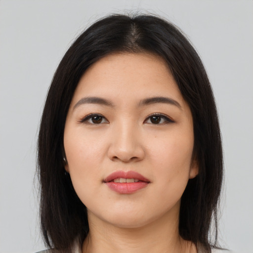 Joyful asian young-adult female with long  brown hair and brown eyes