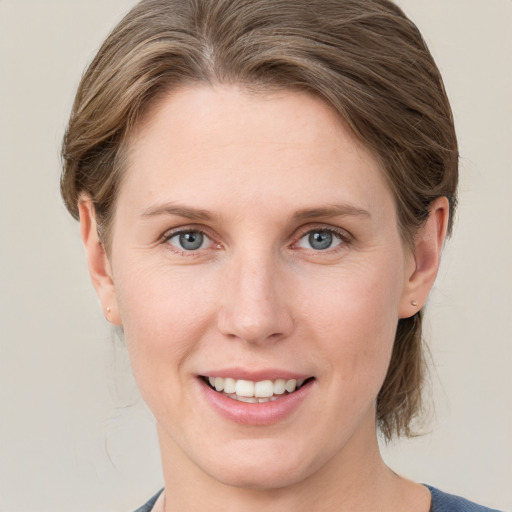 Joyful white young-adult female with medium  brown hair and blue eyes