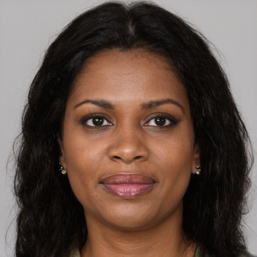 Joyful black young-adult female with long  black hair and brown eyes