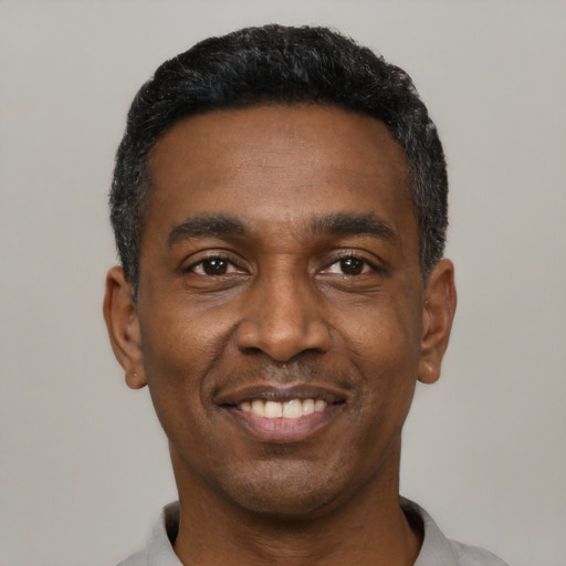 Joyful black young-adult male with short  black hair and brown eyes