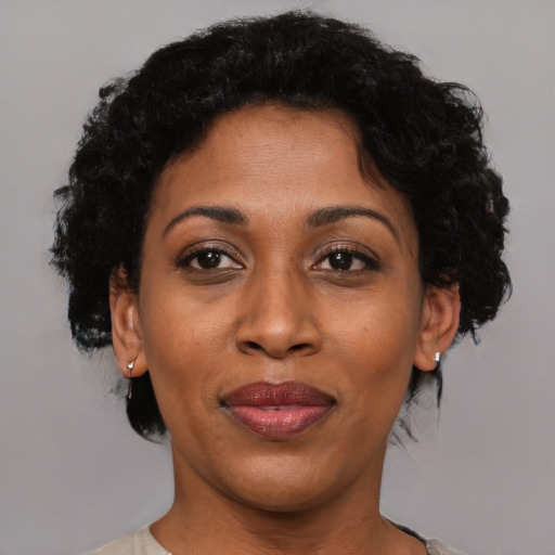 Joyful black adult female with short  brown hair and brown eyes