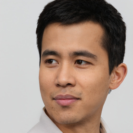Joyful asian young-adult male with short  black hair and brown eyes