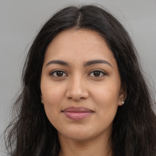 Joyful latino young-adult female with long  brown hair and brown eyes
