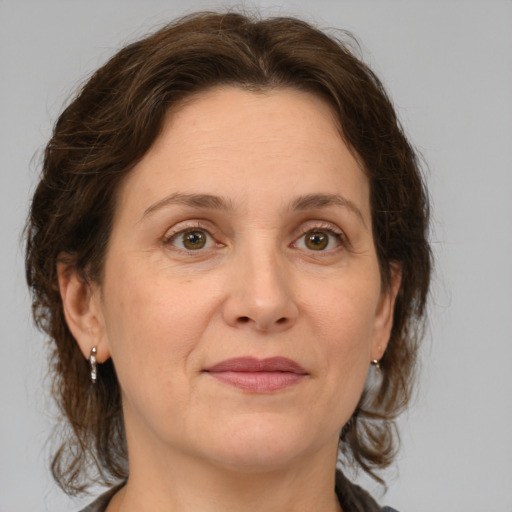 Joyful white adult female with medium  brown hair and green eyes