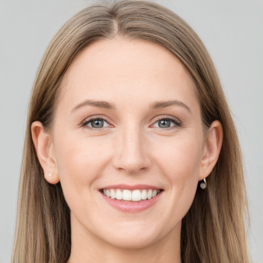 Joyful white young-adult female with long  brown hair and grey eyes