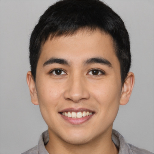 Joyful asian young-adult male with short  brown hair and brown eyes