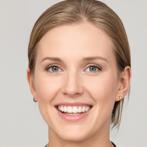 Joyful white young-adult female with medium  brown hair and grey eyes