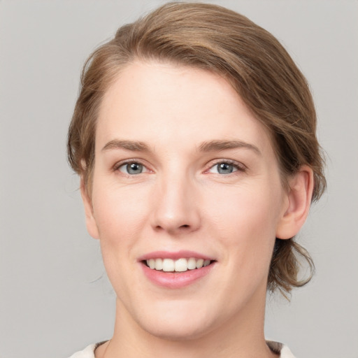 Joyful white young-adult female with medium  brown hair and grey eyes