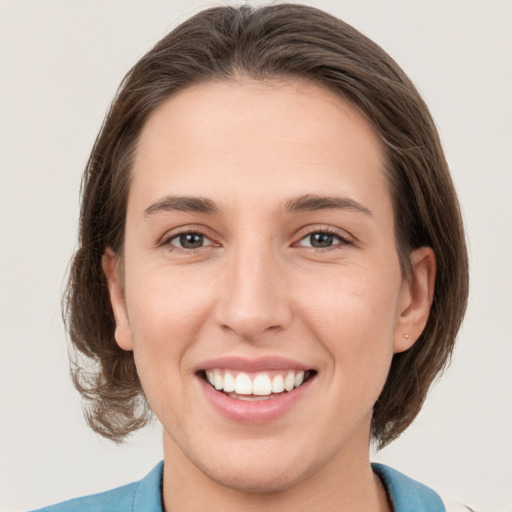 Joyful white young-adult female with medium  brown hair and grey eyes