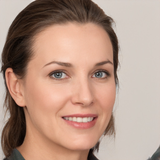 Joyful white young-adult female with medium  brown hair and grey eyes