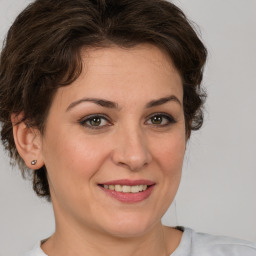 Joyful white young-adult female with medium  brown hair and green eyes