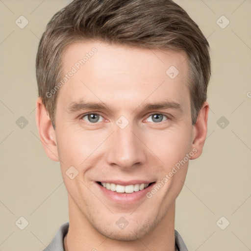 Joyful white young-adult male with short  brown hair and grey eyes