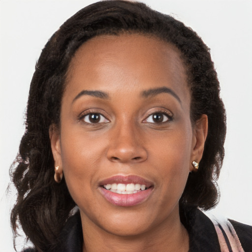 Joyful black young-adult female with long  brown hair and brown eyes