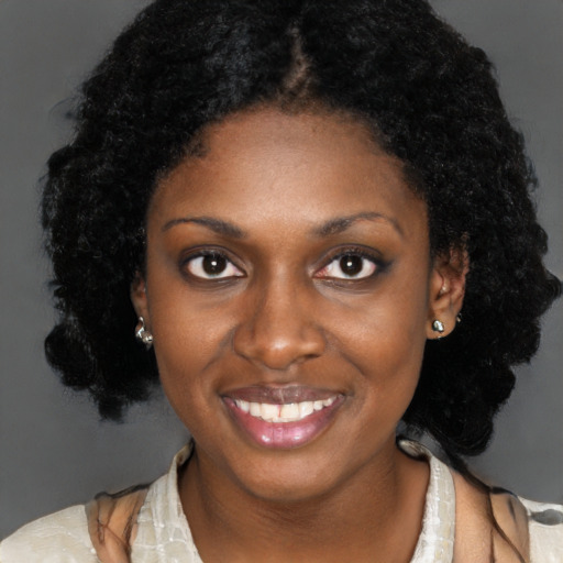 Joyful black young-adult female with long  brown hair and brown eyes
