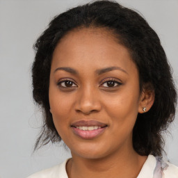 Joyful black young-adult female with long  brown hair and brown eyes