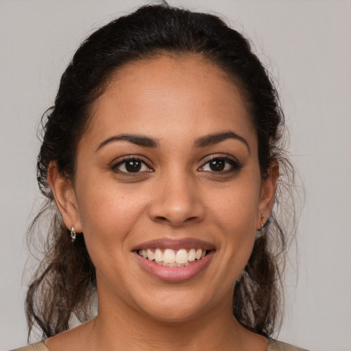 Joyful latino young-adult female with medium  brown hair and brown eyes