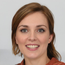 Joyful white young-adult female with medium  brown hair and blue eyes