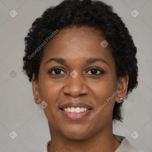 Joyful black adult female with short  black hair and brown eyes