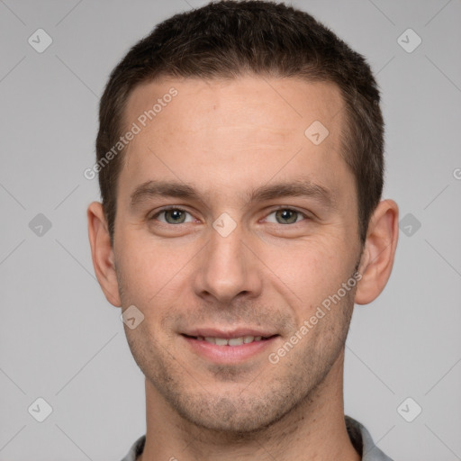 Joyful white young-adult male with short  brown hair and grey eyes