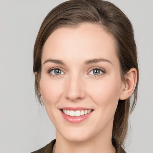 Joyful white young-adult female with medium  brown hair and grey eyes