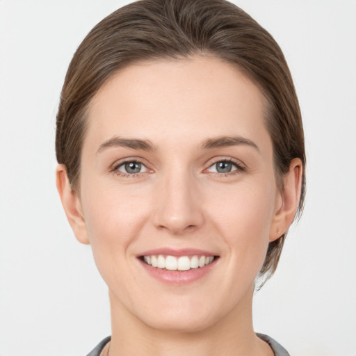 Joyful white young-adult female with short  brown hair and grey eyes