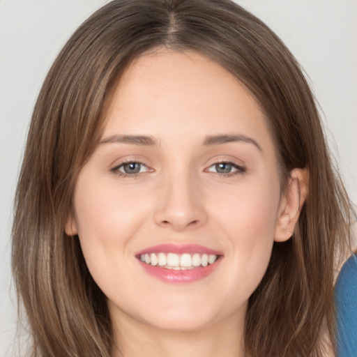 Joyful white young-adult female with long  brown hair and grey eyes