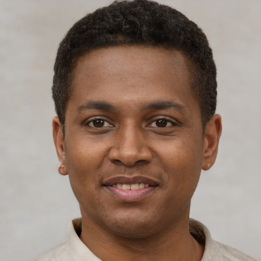 Joyful latino young-adult male with short  brown hair and brown eyes