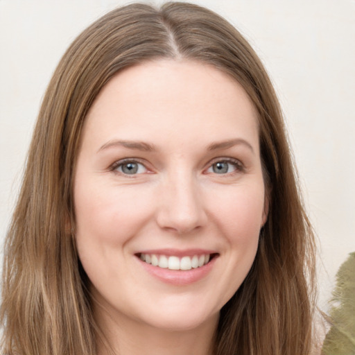 Joyful white young-adult female with long  brown hair and grey eyes