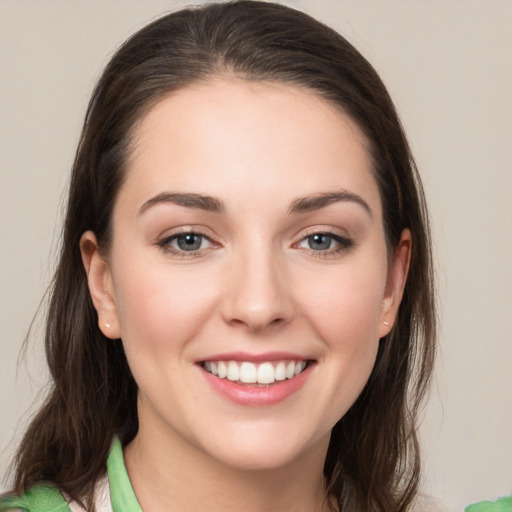 Joyful white young-adult female with medium  brown hair and green eyes