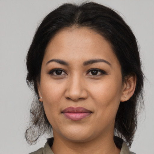 Joyful latino adult female with medium  brown hair and brown eyes