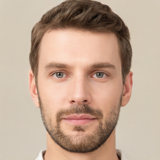 Joyful white young-adult male with short  brown hair and grey eyes