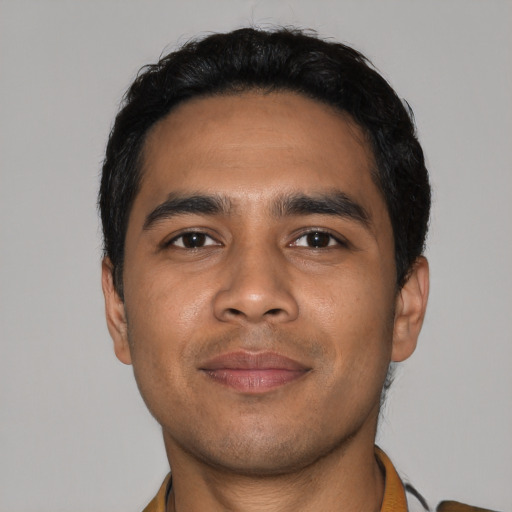 Joyful latino young-adult male with short  black hair and brown eyes