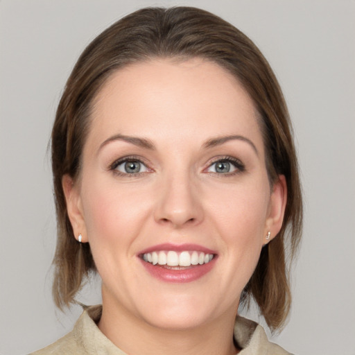 Joyful white young-adult female with medium  brown hair and grey eyes