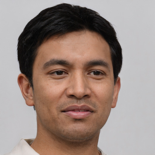 Joyful asian young-adult male with short  black hair and brown eyes