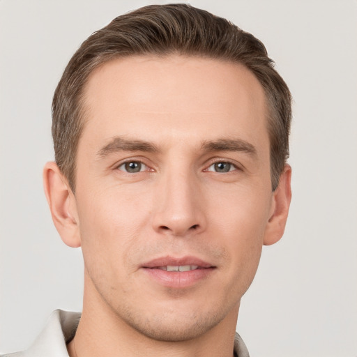 Joyful white young-adult male with short  brown hair and grey eyes